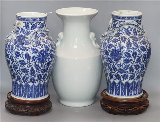 A pair of 19th century Chinese blue and white vases with applied dragons to the neck, wood stands and a white glazed vase (5) tallest 3